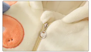 Macro view of heart-shaped metal zipper and thick fleece texture on baby winter jumpsuit