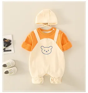 Flat lay of newborn bear jumpsuit set with matching hat and orange cotton stitching