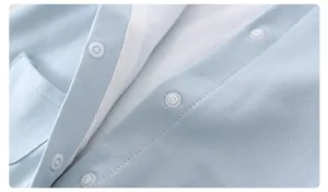 Detail of light blue baby romper featuring smooth snap buttons and soft cotton fabric