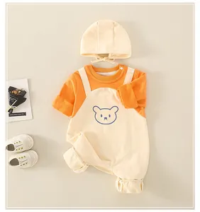 Flat lay of newborn long sleeve bear romper set with matching hat and snap buttons