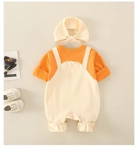 Flat lay of newborn baby romper set with matching hat in orange and cream cotton