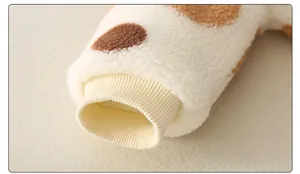 Detailaufnahme der weichen Baby-Plüschjacke mit braunen Punkten und Rippbündchen