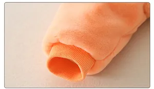 Close-up of orange baby romper showing thick coral fleece texture and ribbed cuffs