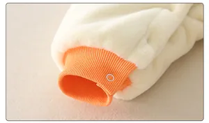 Detail of warm baby jumpsuit sleeve with orange ribbed cuff and white snap button closure