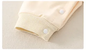 Detail von Rippbündchen und weißen Druckknöpfen am Baby-Strampler aus Bio-Baumwolle