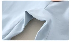 Macro detail of soft light blue cotton fabric texture and precise stitching on baby romper