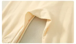Detailed macro view of soft beige cotton newborn romper with reinforced crotch stitching
