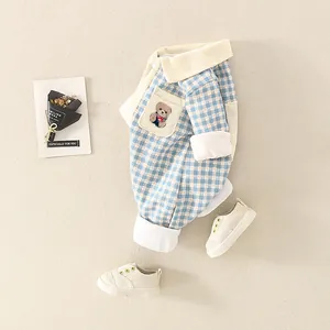 Détail de la barboteuse bébé à carreaux bleu et blanc avec poche ours et col souple
