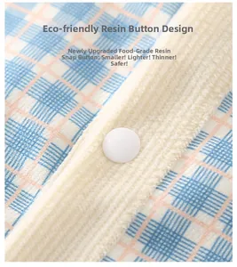 Détail d'un bouton pression écologique sur le tissu à carreaux d'une barboteuse bébé
