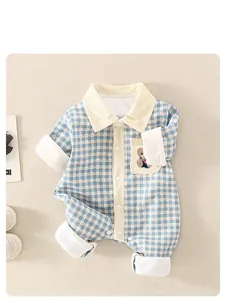Détail d'un barboteuse bébé à carreaux bleus avec poche ourson et col en velours
