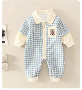 Détail de la grenouillère bébé à carreaux bleus avec broderie ours et boutons pression