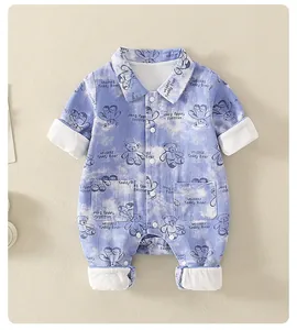 Detail of baby cotton romper featuring blue teddy bear print and button-up polo collar