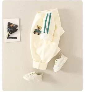 Detail of baby cotton sweatshirt featuring green side stripes and cute bear embroidery