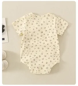 Detalle de un body para bebé en algodón con estampado floral y mangas cortas suaves