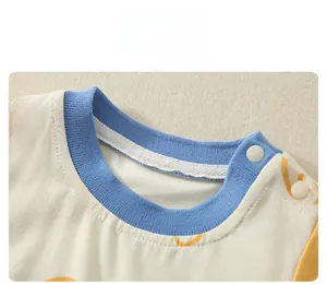 Détail du body bébé en coton avec motifs de cœur orange et col bleu côtelé