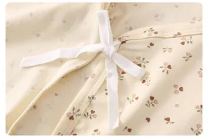 Detalle de body para bebé de algodón con estampado floral y lazos blancos