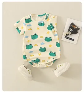 Detail eines Baby-Baumwoll-Stramplers mit Froschdruck, Druckknöpfen und passenden Schuhen