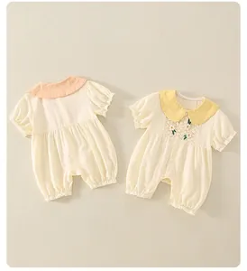 Detailaufnahme von Baby-Bodys aus Baumwolle mit Stickerei und gerafften Details