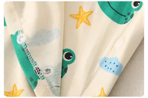 Detailaufnahme von Baby-Strampler aus Baumwolle mit Dinosaurier-Prints und Druckknöpfen