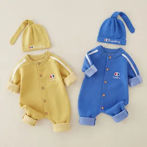Detailed close-up of knitted baby rompers with matching pointed hats in yellow and blue