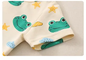 Detailaufnahme der Baby-Strampler aus Baumwolle mit Druckknöpfen und Frosch-Cartoon-Muster
