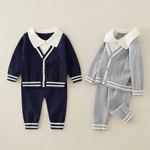 Flat lay of baby knitted cardigan and pants sets in navy blue and grey colors