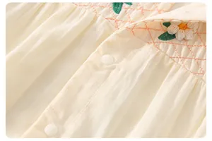 Detail eines Baby-Bodys aus Baumwolle mit Gänseblümchen-Stickerei und Druckknöpfen