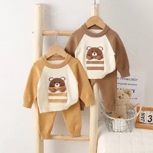 Detail of baby knitted set showing 3D cartoon bear patch and soft cotton texture
