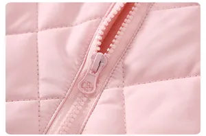 Dettaglio del tessuto trapuntato rosa e della cerniera in resina della tutina invernale neonato