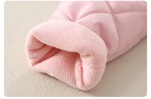 Dettaglio del tessuto trapuntato rosa e della calda fodera in pile per neonati