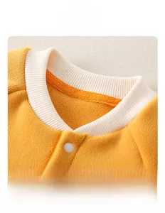 Close-up of white ribbed stand collar and snap buttons on yellow fleece baby romper