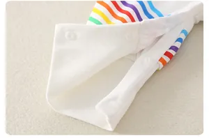 Detail eines Baby-Stramplers mit Regenbogenstreifen und weißen Druckknöpfen aus Baumwolle