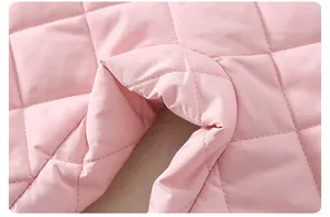 Dettaglio del tessuto trapuntato a rombi rosa per pagliaccetto invernale neonato