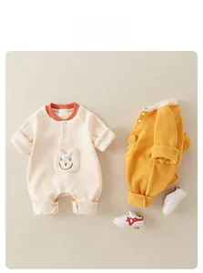 Detail showing soft fleece texture and cute smiley face pockets on baby jumpsuits
