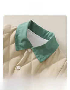 Detail view of baby quilted romper with green contrast collar and white snap buttons