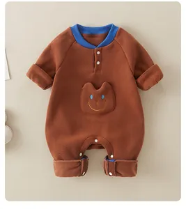 Detail of baby fleece romper with blue ribbed collar and smiling face pocket embroidery