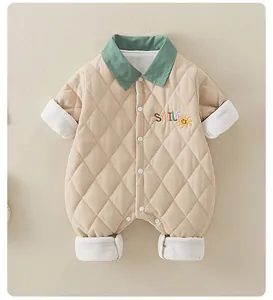 Detailed view of quilted baby romper with smile embroidery and contrast green collar