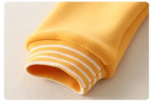Close-up of yellow fleece baby romper featuring ribbed cuffs with white stripe details