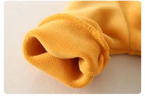 Detail of baby romper with warm yellow knit outer and soft fleece lining texture
