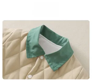 Detail of baby quilted romper showing green collar and diamond pattern stitching