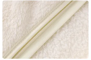Close-up of soft cream flannel fabric with neat stitching and high-quality zipper detail