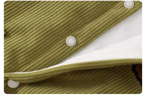 Close-up of olive green corduroy baby romper with warm lining and white snap buttons