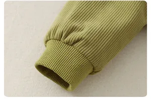 Detailed close-up of ribbed knit cuffs on an olive green baby winter bodysuit