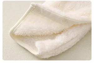 Close-up of soft off-white flannel baby romper showing fuzzy texture and plastic snap buttons