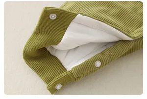 Detailed macro of baby romper with ribbed fabric, white fleece lining and resin snap buttons