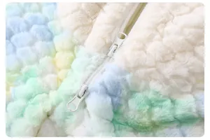 Detail of baby rainbow plush romper featuring a smooth white double zipper closure