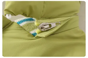 Detailed macro view of the smooth metal zipper and green fabric on the winter baby romper