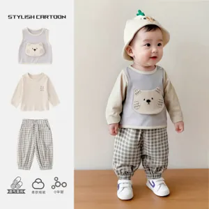 Detail of infant 3-piece set showing bear vest, white tee, and plaid pants for boys