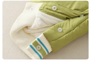 Detail of green baby winter jumpsuit showing warm fleece lining and striped ribbed cuffs