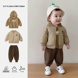Detail of infant autumn outfit set featuring quilted jacket, hoodie, and soft stripe pants